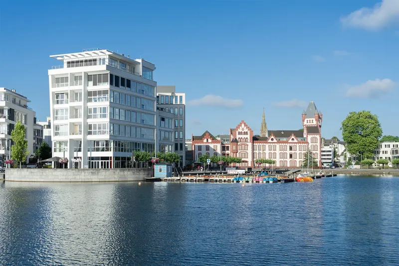 Phoenix See Dortmund: Imposante Wasserfront mit kontrastreichem Zusammenspiel von moderner Glasarchitektur und historischen Backsteingebäuden. Attraktive Freizeitmöglichkeiten am Wasser mit Bootsverleih und Promenade in urbaner Lage. Beliebtes Naherholungsziel im Ruhrgebiet.
