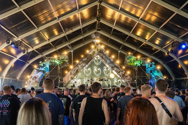 Erleben Sie elektrisierende Festival-Atmosphäre unter einem beeindruckenden Zeltdach mit modernster Lichtshow, DJ-Performance und energiegeladener Crowd. Indoor Electronic Music Festival mit einzigartiger Bühnenarchitektur und state-of-the-art Produktionstechnik.

