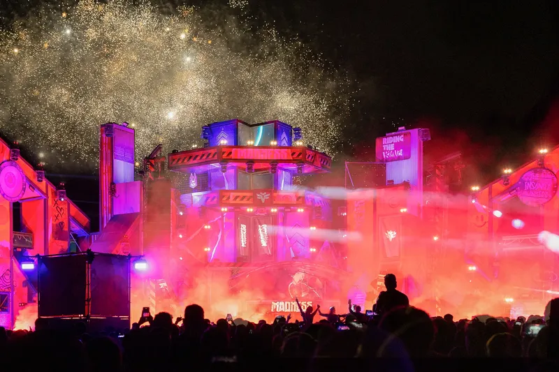 Feuerwerk und Festivalbühne bei Nacht mit bunten Lichtern
